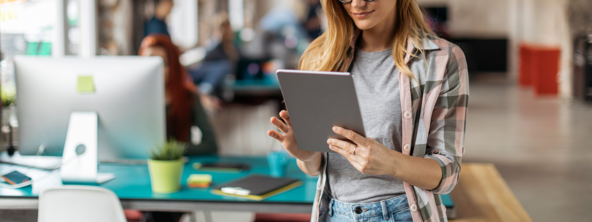 Kvinna tittar på en ipad i kontorsmiljö