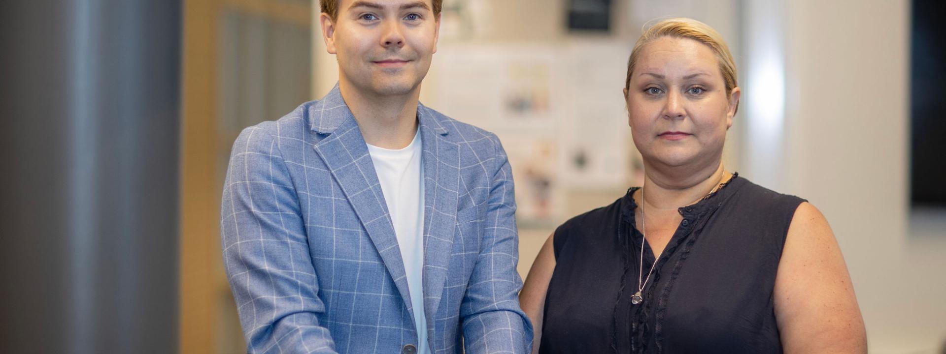 Man i blå kavaj och kvinna i mörkblå blus