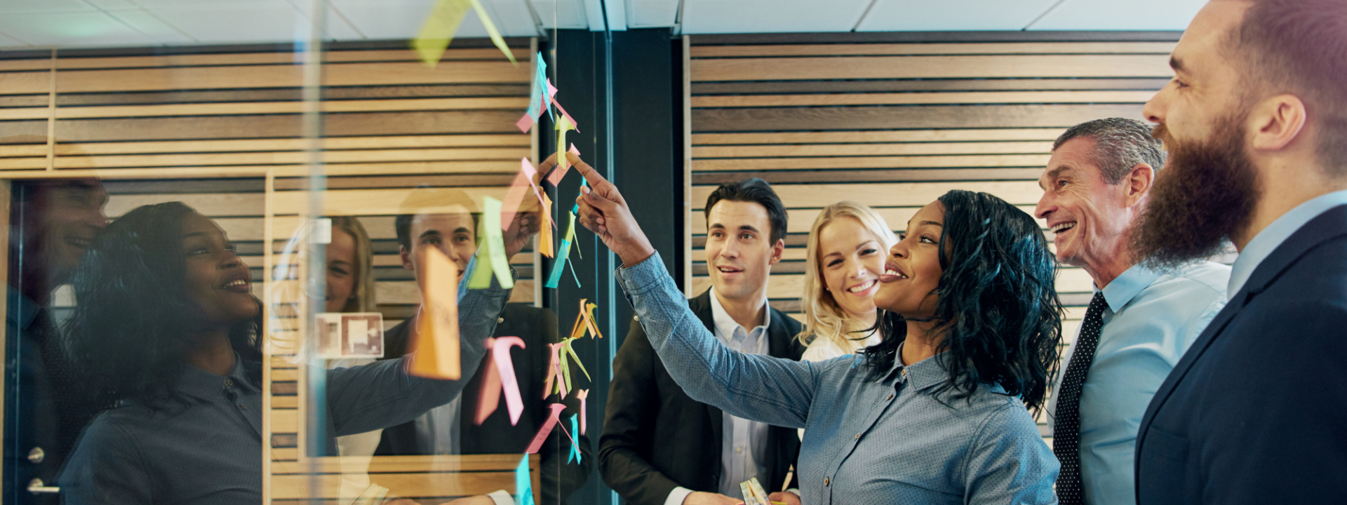 en grupp personer tittar på en tavla med post its