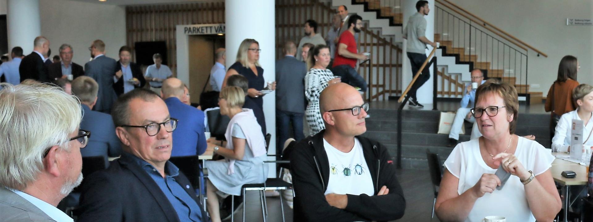 Människor sitter runt ett bord och pratar