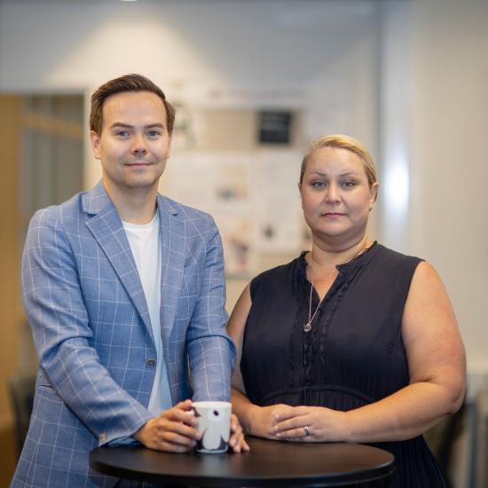 Man i blå kavaj och kvinna i mörkblå blus