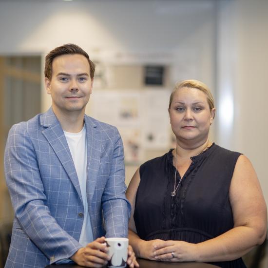Man i blå kavaj och kvinna i mörkblå blus
